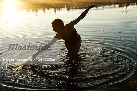 Femme touchant l'eau dans le lac