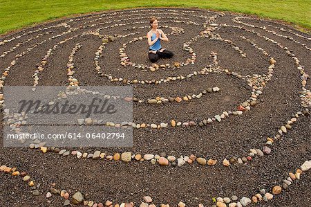 Woman meditating in stone labyrinth