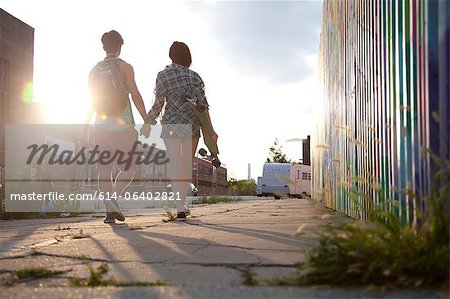 Jeune couple marchant main dans la main, de vue arrière