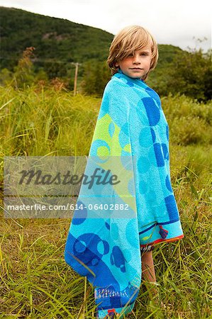 Boy wrapped in a towel outdoors