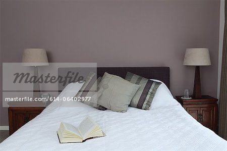 Bedroom with open book on bed