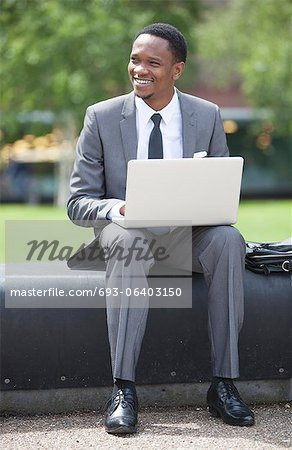 Portrait of African American Businessman working on a laptop outdoors