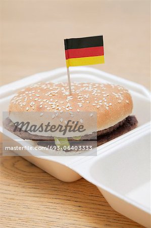 Fresh hamburger with German flag decoration on wooden surface