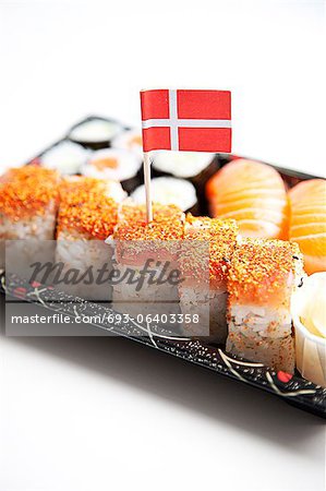 Sushi food on tray with Danish flag against white background