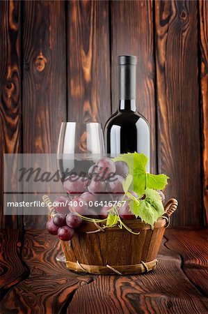 Vin rouge avec un verre de vin sur fond en bois