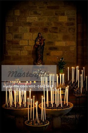 Kerzen in einer Kirche, die Jungfrau Maria Jesus-Statue im Hintergrund halten