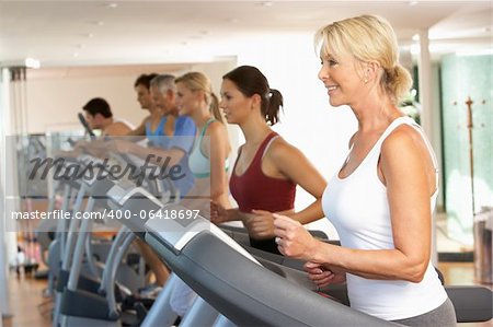 Senior Woman On Running Machine In Gym