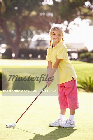 Young Girl Practising Golf On Putting On Green