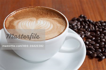 Coffee cup and beans on a wood table