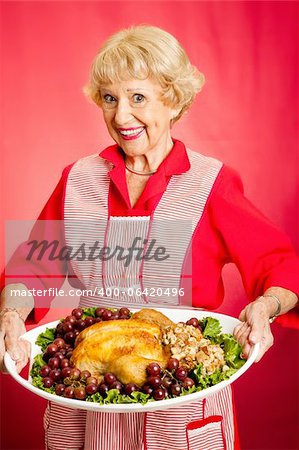 Jolie grand-mère servent le repas de vacances Turquie. Fond rouge.