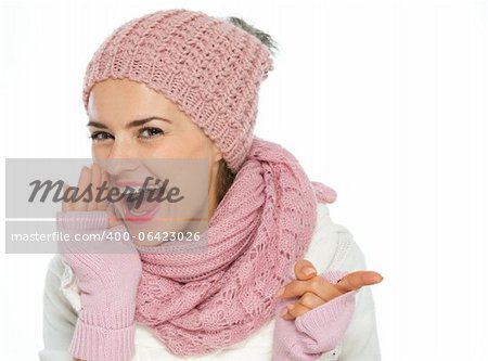 Heureuse jeune femme en vêtements d'hiver en tricot pointant sur copy space