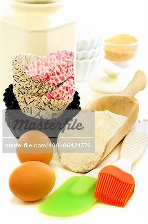 Forms for baking cakes and scoop of flour on a white background.