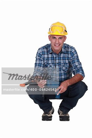 Man crouching with drill