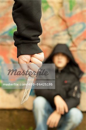 Boy looks at a man with a knife