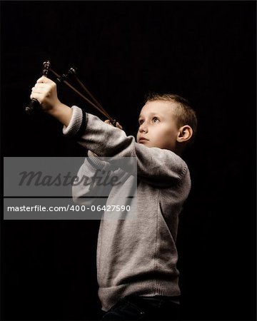 Little boy shooting with a slingshot