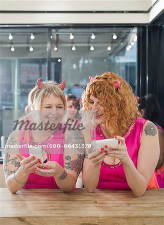 Women Wearing Devil Horns and Costumes Using Cellular Telephones, Oakland, Alameda County, California, USA