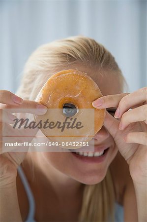 Woman peering through donut hole