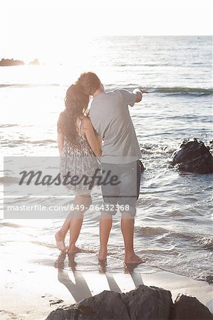 Couple admiring ocean on beach
