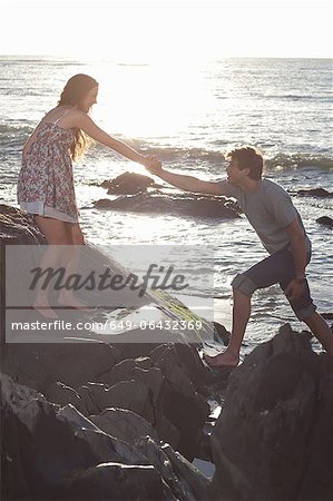 Roches escalade de couple sur la plage