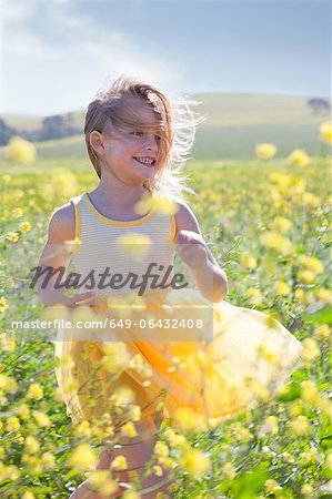 Jeune fille souriante, jouant dans le champ de fleurs