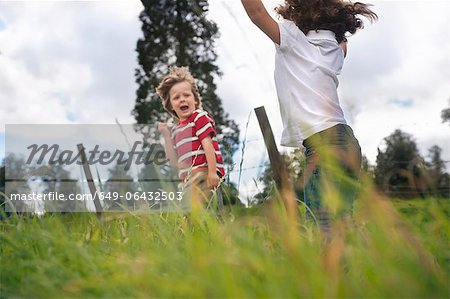 Kinder spielen im grünen Feld