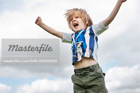 Boy with medals cheering outdoors