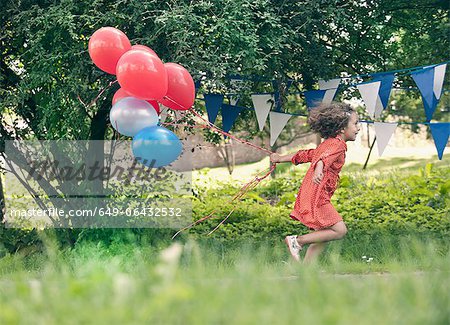 Mädchen mit Haufen Luftballons im freien