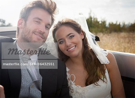 Newlywed couple sitting in convertible