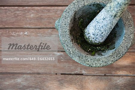 Herbs being ground in pestle and mortar