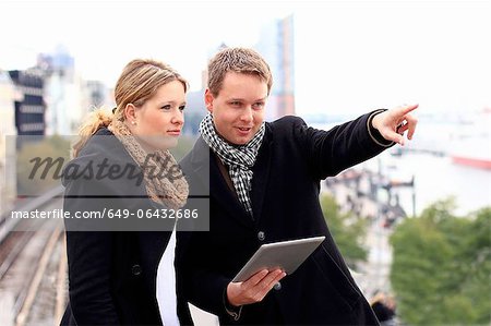 Couple using tablet computer outdoors