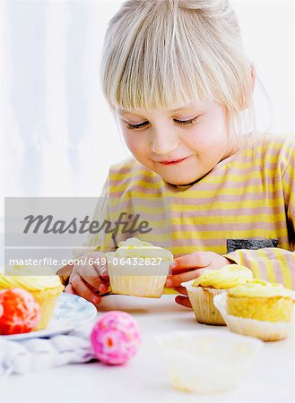 Smiling girl admiring cupcake