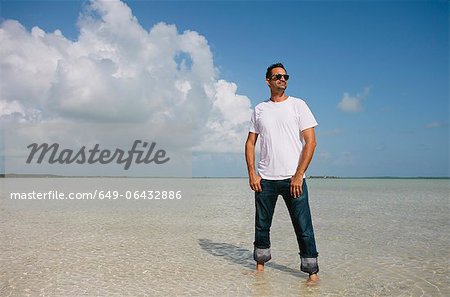 Mann, stehend im Wasser am tropischen Strand