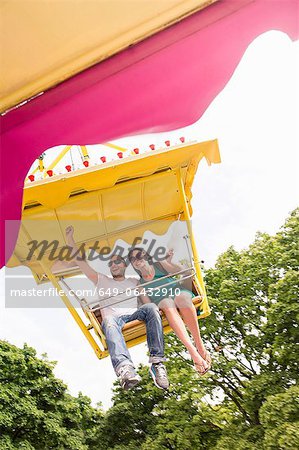Couple riding amusement park ride