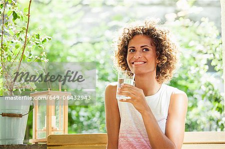Smiling woman drinking glass of water