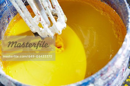 Vat of yellow paint being mixed