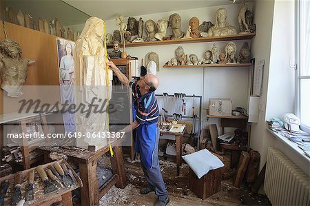 Sculptor measuring wooden figure