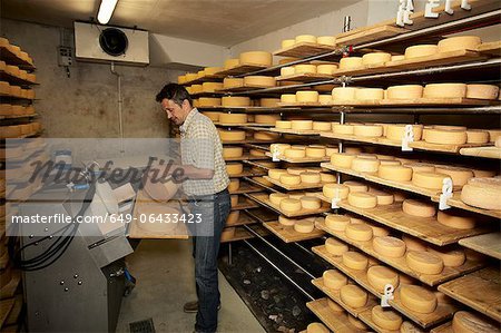 Arbeiter schlichten Rad der Käse im shop Arbeiter schlichten Rad der Käse im shop