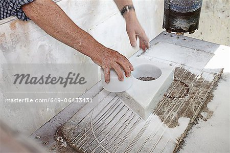 Worker pulling cut stone from block