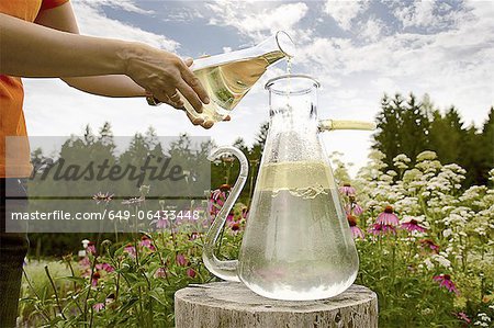 Worker pouring chemicals in field