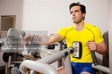 Mann mit Trainingsgeräten in Fitness-Studio