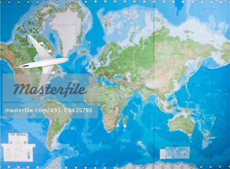 Model airplane flying over world map