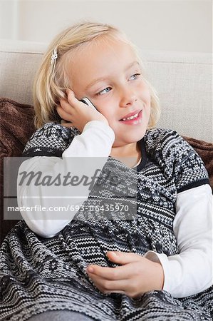 Junges Mädchen mit Handy auf sofa