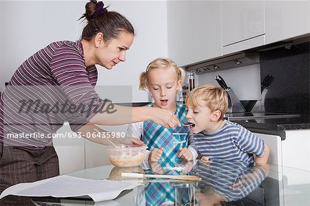 Mes enfants, cuisson et dégustation de pâte de cookie dans la cuisine