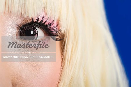 Portrait de gros plan du visage de jolie jeune femme aux cheveux blonds sur fond bleu Portrait de gros plan du visage de jolie jeune femme aux cheveux blonds sur fond bleu