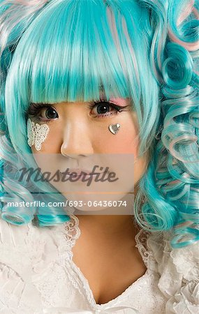 Close-up portrait de jeune femme aux cheveux bleus habillée comme une poupée