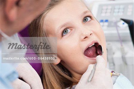 Close-up of Dentist Checking Girl's Teeth during Appointment, Germany