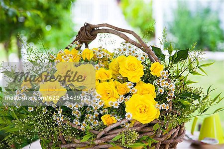 Basket of yellow roses and chamomile flowers