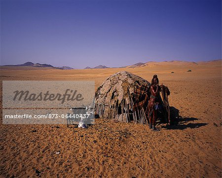 Portrait de femme Himba, debout près de cabane avec chèvres Namibie, Afrique