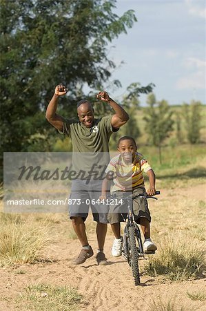 Father Helping Son Ride Bike