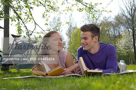 Junges Paar auf einer Wiese lesen